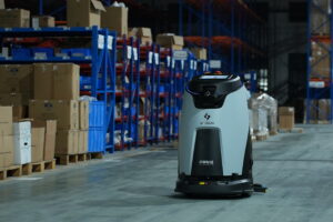 Robot nhà xưởng di chuyển trong lối đi giữa các kệ hàng của kho nhà máy