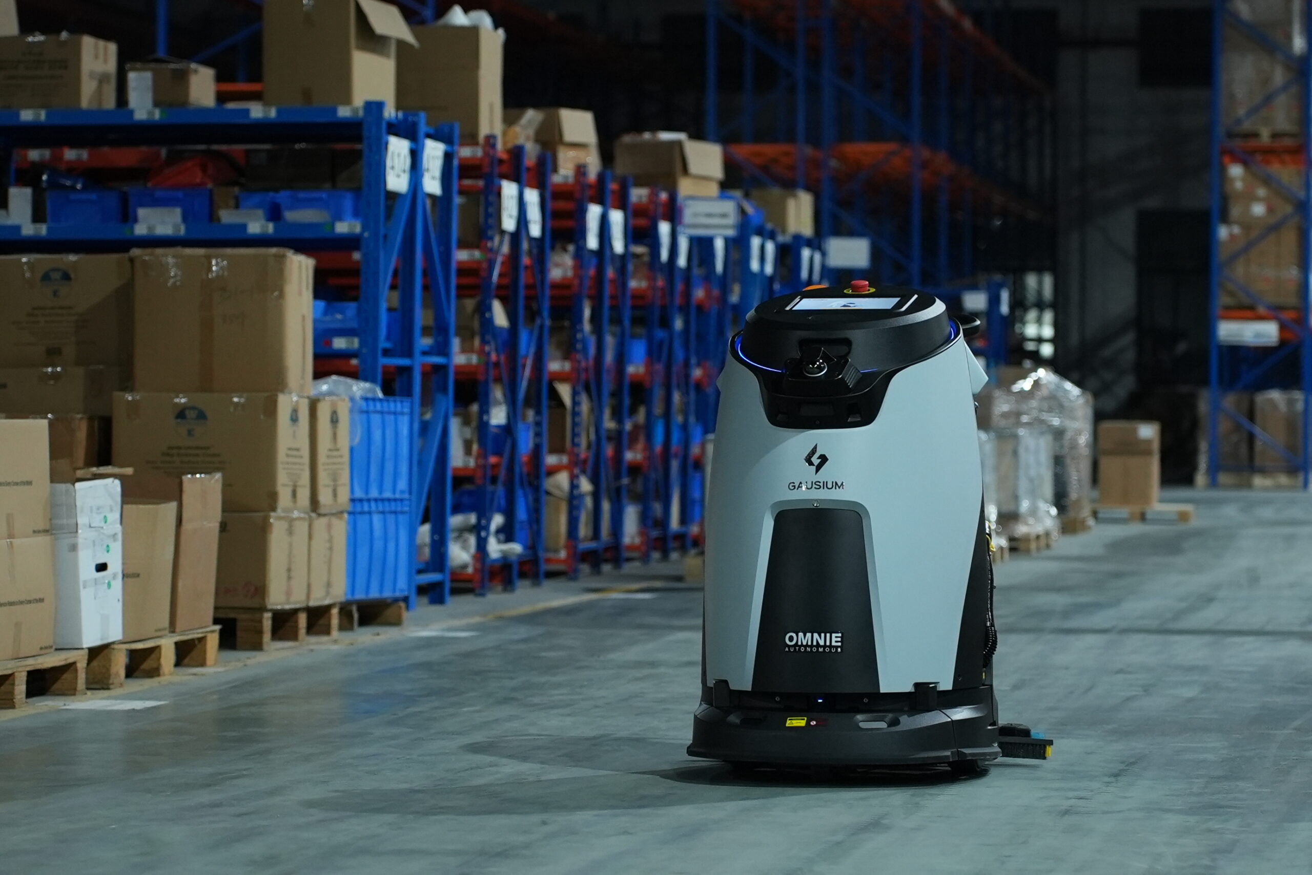 Robot nhà xưởng di chuyển trong lối đi giữa các kệ hàng của kho nhà máy