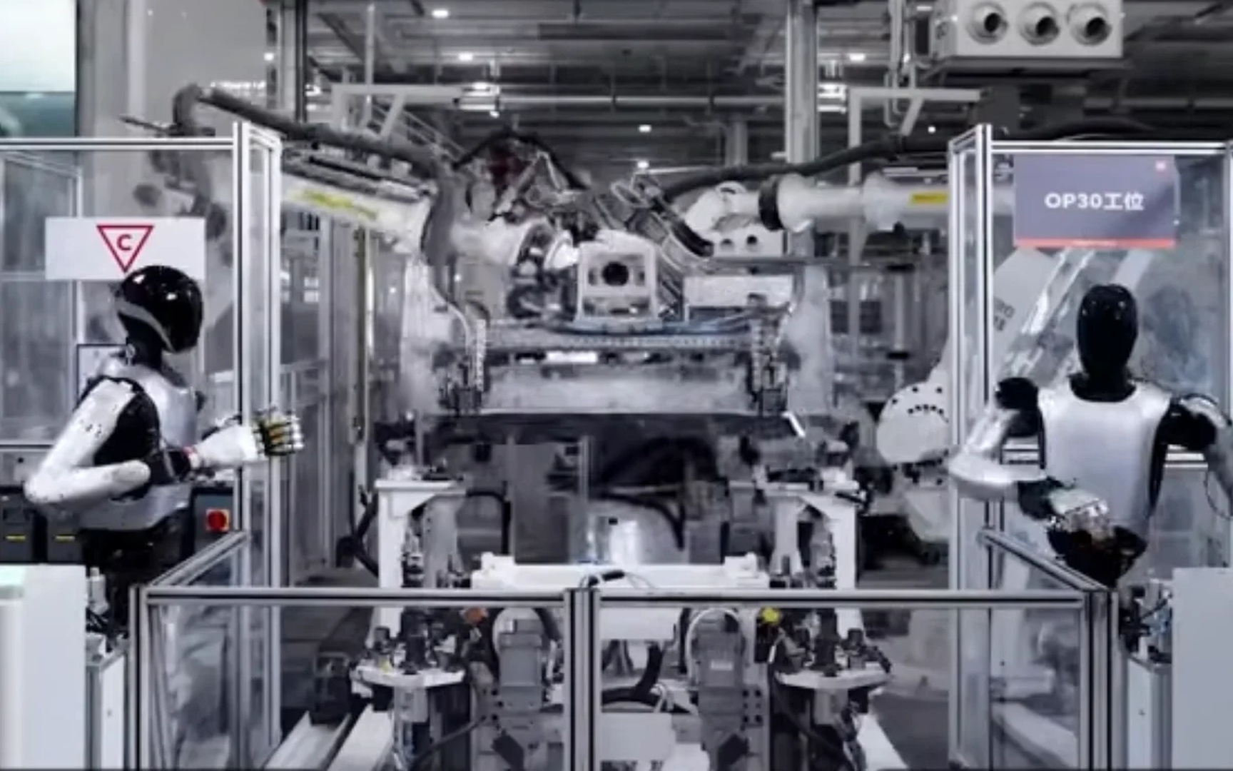 Hai robot hình người cùng thao tác đối xứng tại trạm lắp ráp kép trong nhà máy Xiaomi
