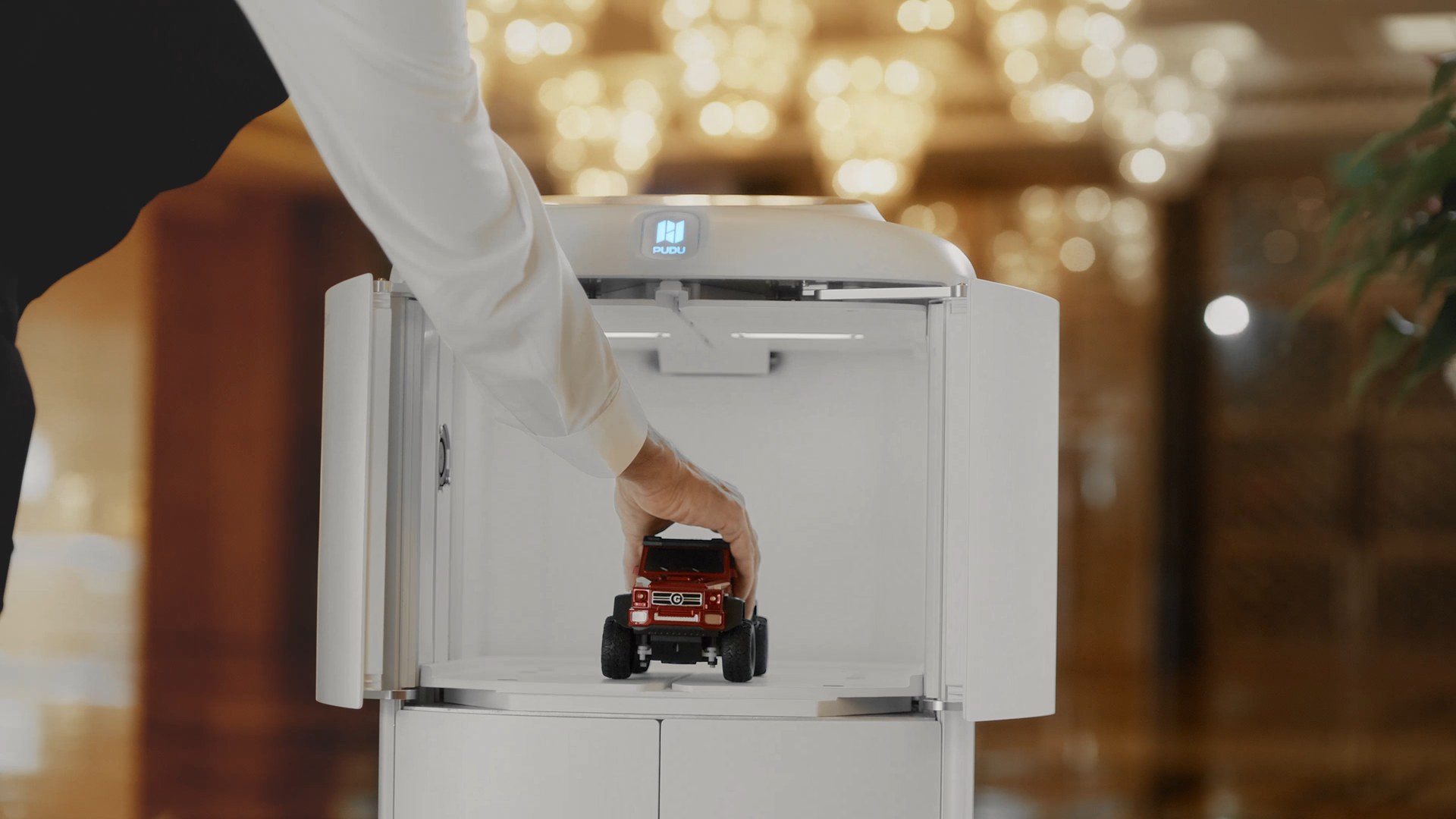 Nhân viên đặt đồ vào khoang kín của robot vận chuyển trước khi giao