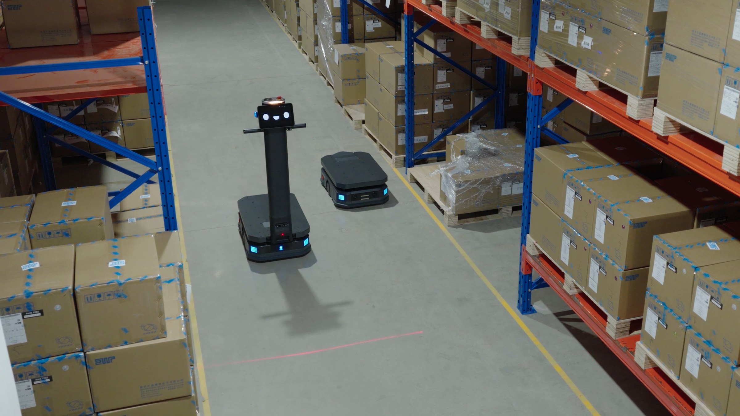 AMR robot di chuyển trong lối đi giữa các dãy giá kệ kho hàng