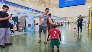 Khách tham quan thích thú tương tác với robot Booster K1 áo số 7 tại VIIF 2026