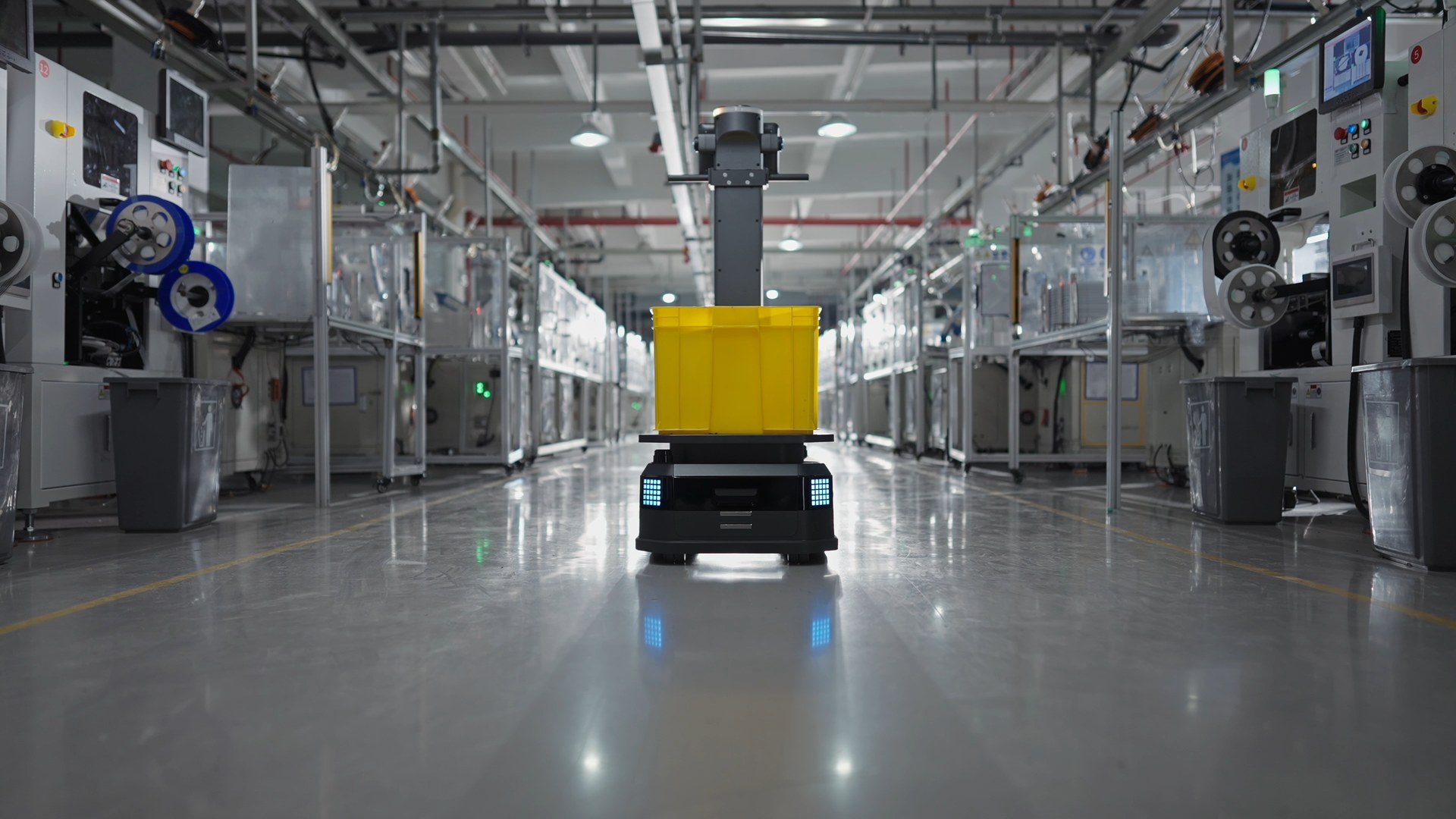 Robot vận chuyển chở thùng hàng dọc lối đi trong nhà máy