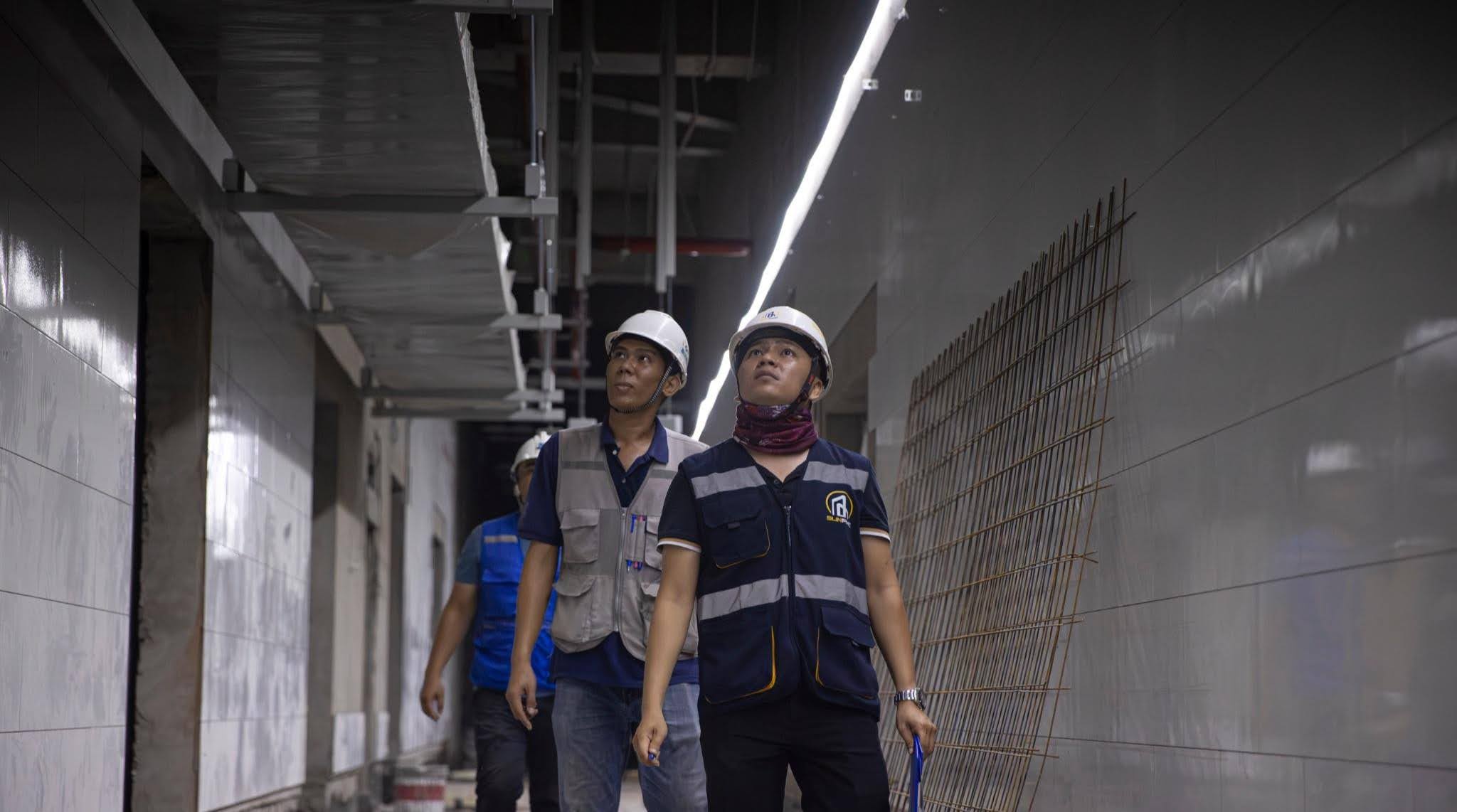 Kỹ sư kiểm tra tiến độ tại hành lang kỹ thuật nhà máy suất ăn hàng không