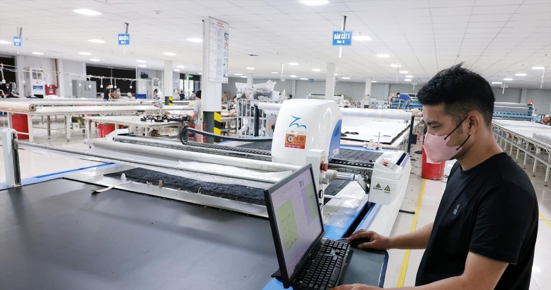Kỹ thuật viên điều khiển máy cắt tự động qua máy tính