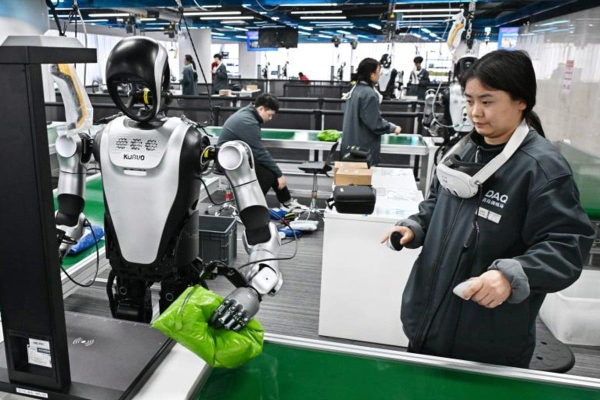 Người huấn luyện dùng tay cầm điều khiển dạy robot hình người thao tác cầm nắm