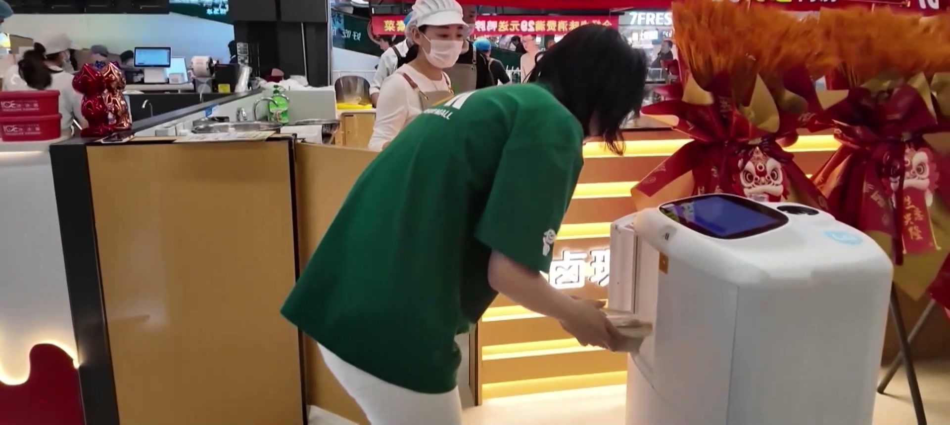 Nhân viên đặt món lên robot giao hàng tại nhà hàng tự động hóa Bắc Kinh