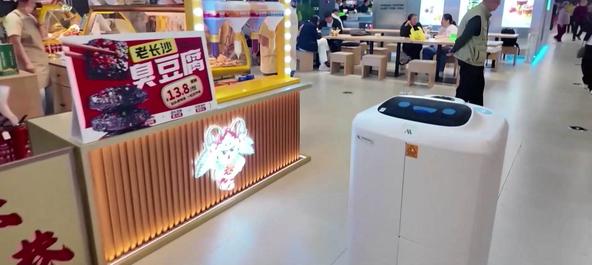 Robot giao món di chuyển giữa khu bàn ăn của nhà hàng tự động hóa vận hành bằng robot
