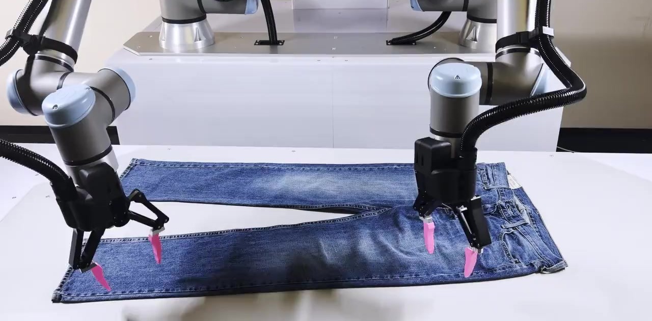 Robot hai tay của Sereact gấp quần jean trong quy trình xử lý hàng hoàn trả nhờ vòng lặp huấn luyện AI