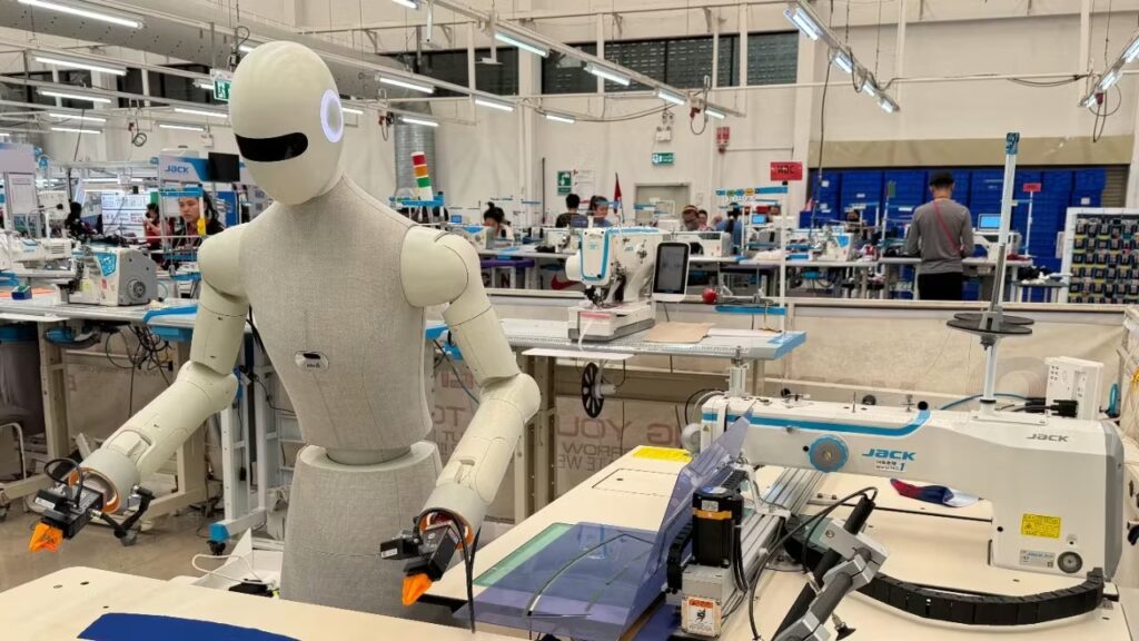Robot hình người vào nhà máy may mặc, đứng cạnh máy may công nghiệp Jack