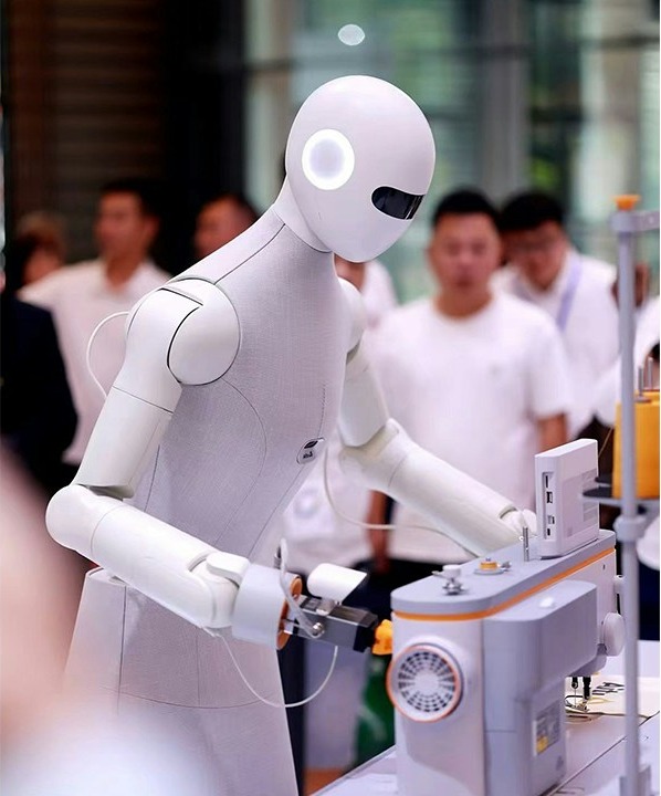 Robot hình người Aitu thao tác trên máy may tại một triển lãm công nghệ