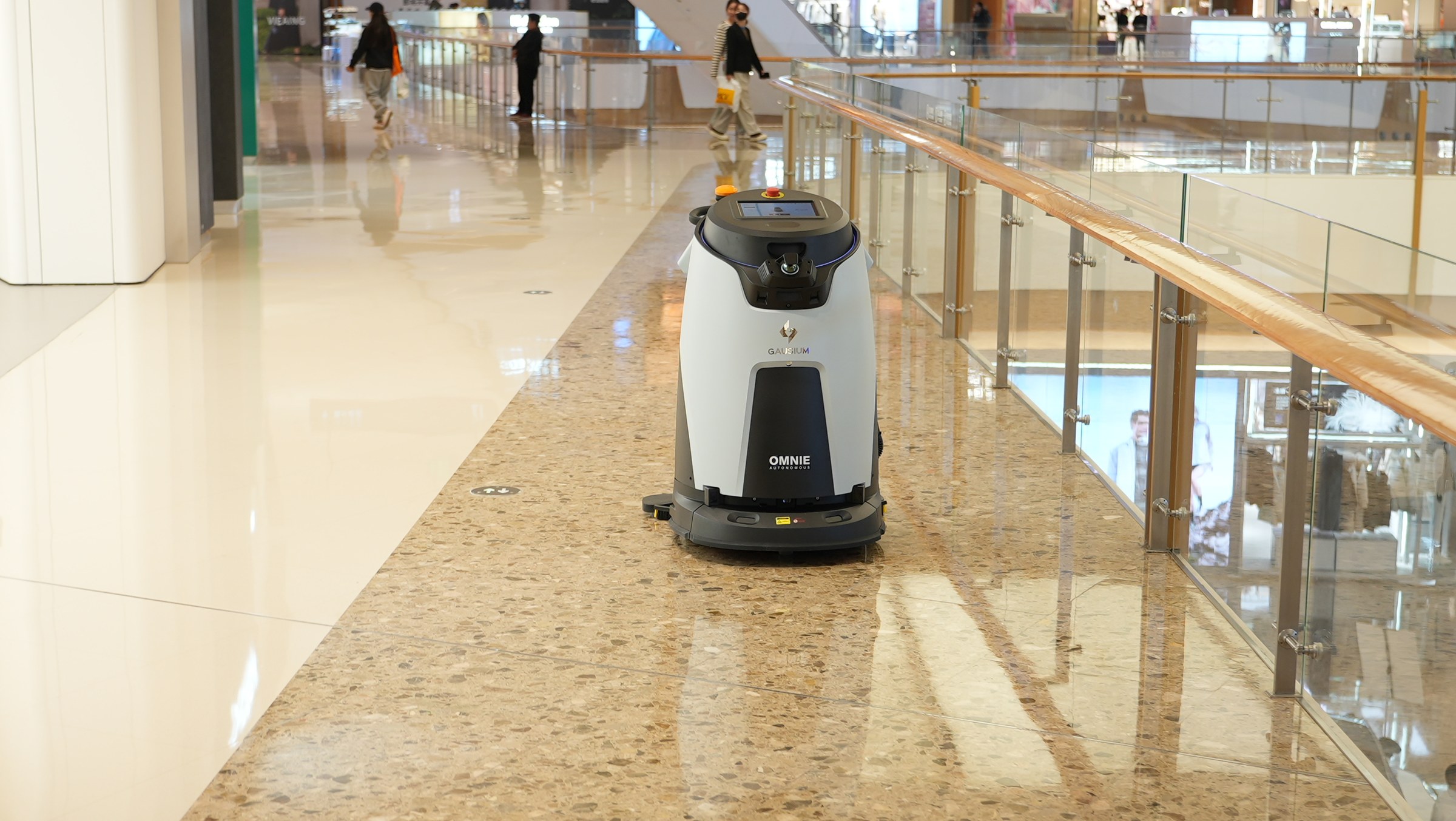 Robot lau sàn công nghiệp Gausium Omnie làm việc trên hành lang có khách qua lại